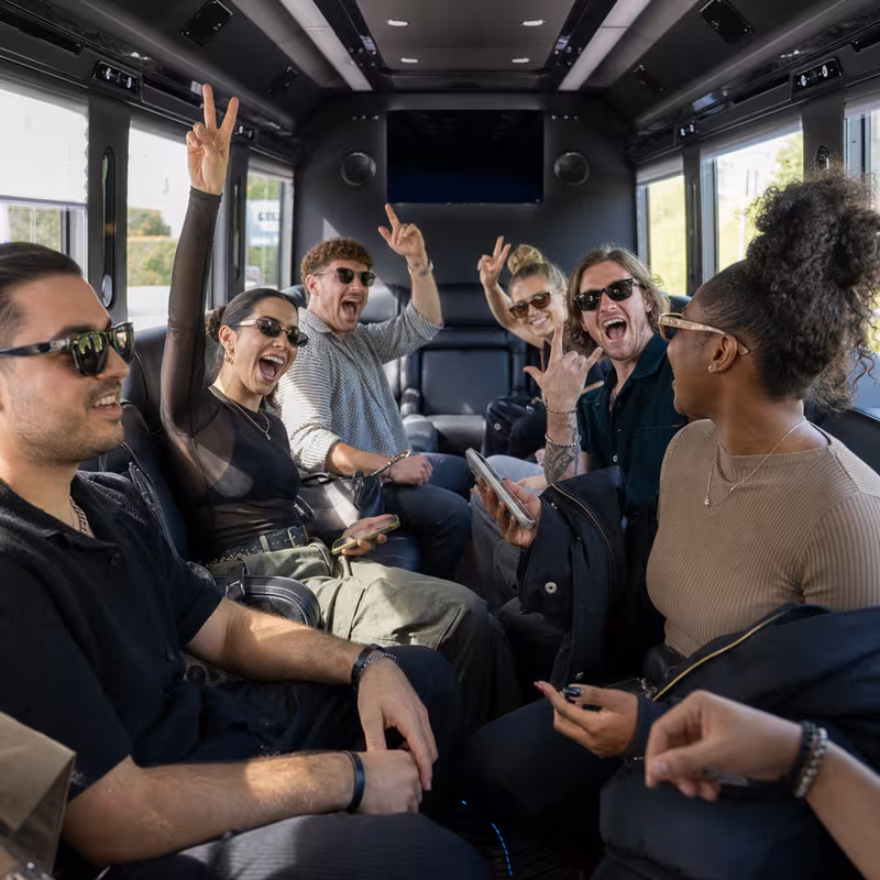 Group boarding a white charter bus for Concert Transportation transportation in Albuquerque