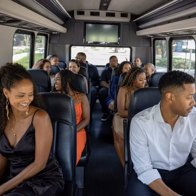 Group boarding a white charter bus for Private Event Transportation transportation in Albuquerque
